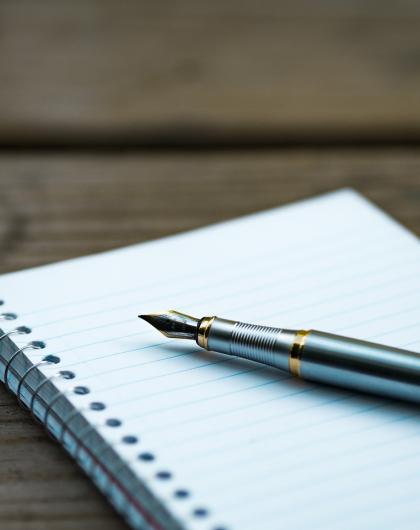 Image d'illustration pour l'atelier. Le visuel montre un stylo plume posé sur un carnet. La page est blanche. 