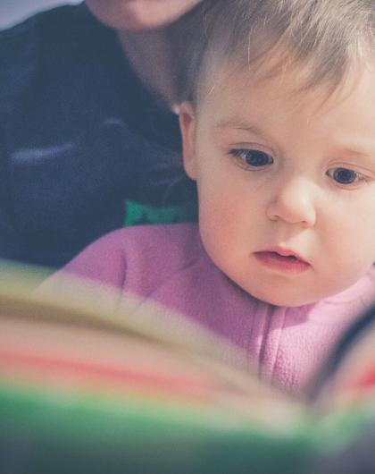 Illustration d'un bébé devant un livre