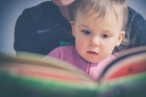 Illustration d'un bébé devant un livre