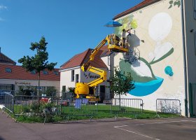Le street artist Eskat au travail sur une fresque Un mur Une oeuvre à Fontenay-Mauvoisin